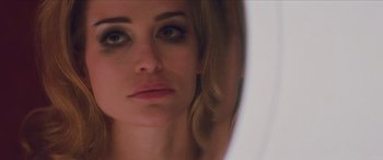 Movie still from “Looper” (2012), directed by Rian Johnson – A woman's face in a bathroom mirror; Close Up shot, Over the shoulder angle
