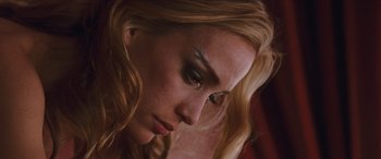 Movie still from “Looper” (2012), directed by Rian Johnson – A person with long blonde hair; Close Up shot, Low angle