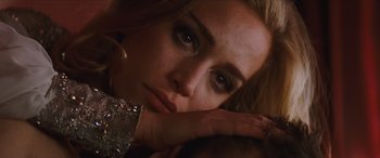 Movie still from “Looper” (2012), directed by Rian Johnson – A woman's face as she rests her head on her hand; Close Up shot, Over the shoulder angle
