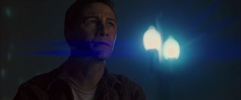 Movie still from “Looper” (2012), directed by Rian Johnson – A person looking up at a light; Close Up shot, Low angle
