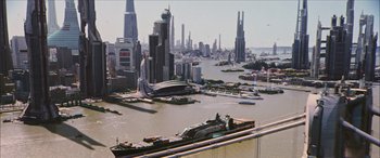 Movie still from “Looper” (2012), directed by Rian Johnson – An aerial view of a large city with a bridge in the foreground; Extreme Wide shot, High angle