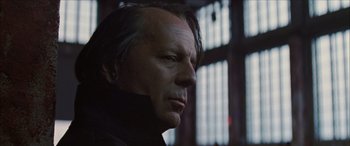 Movie still from “Looper” (2012), directed by Rian Johnson – A man's face in front of a window; Close Up shot, Low angle