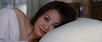 Movie still from “Looper” (2012), directed by Rian Johnson – A beautiful woman laying on top of a white pillow; Close Up shot, High angle