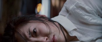 Movie still from “Looper” (2012), directed by Rian Johnson – A woman with a bandage on her head; Extreme Close Up shot, Overhead angle