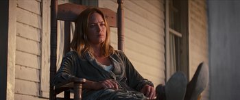 Movie still from “Looper” (2012), directed by Rian Johnson – A woman sitting in a rocking chair in a robe; Medium shot, Low angle