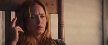 Movie still from “Looper” (2012), directed by Rian Johnson – A person sitting in a chair; Close Up shot, Low angle