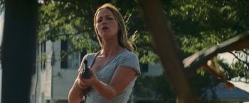 Movie still from “Looper” (2012), directed by Rian Johnson – A woman holding a camera in a park setting; Medium shot, Low angle