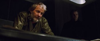 Movie still from “Looper” (2012), directed by Rian Johnson – An older man sitting in front of a piano in a dark room; Close Up shot, Low angle