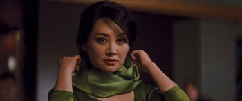 Movie still from “Looper” (2012), directed by Rian Johnson – A woman wearing a green scarf around her neck; Close Up shot, Over the shoulder angle