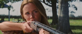 Movie still from “Looper” (2012), directed by Rian Johnson – A woman holding a gun in her hands; Close Up shot, Low angle