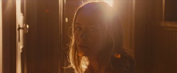 Movie still from “Looper” (2012), directed by Rian Johnson – A woman with long blonde hair is in the sunlight; Close Up shot, Low angle