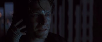 Movie still from “Looper” (2012), directed by Rian Johnson – A person looking at the camera; Close Up shot, Low angle
