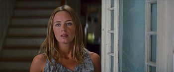 Movie still from “Looper” (2012), directed by Rian Johnson – A woman standing in front of a white door; Close Up shot, Over the shoulder angle