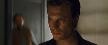 Movie still from “Looper” (2012), directed by Rian Johnson – A man's face in the dark; Close Up shot, Low angle