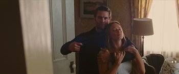 Movie still from “Looper” (2012), directed by Rian Johnson – A man and a woman holding a gun in a room; Medium shot, Low angle