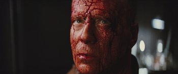 Movie still from “Looper” (2012), directed by Rian Johnson – A person with blood all over his face; Close Up shot, Low angle