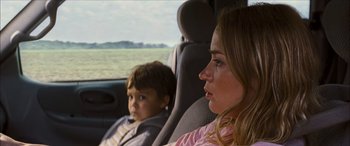 Movie still from “Looper” (2012), directed by Rian Johnson – A woman and a boy sitting in the back of a car; Close Up shot, Over the shoulder angle