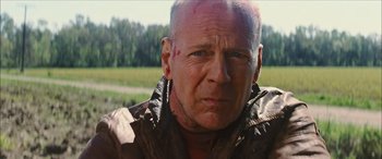 Movie still from “Looper” (2012), directed by Rian Johnson – A person wearing a leather jacket; Close Up shot, Low angle
