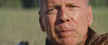 Movie still from “Looper” (2012), directed by Rian Johnson – A man's face with sweat coming off of his face; Extreme Close Up shot, Low angle