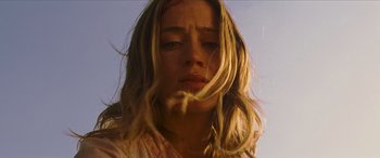 Movie still from “Looper” (2012), directed by Rian Johnson – A person with long blonde hair; Close Up shot, Low angle