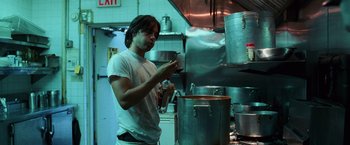 Movie still from “Lord of War” (2005), directed by Andrew Niccol – A man standing in front of a pot in a kitchen; Medium shot, Low angle