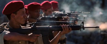 Movie still from “Lord of War” (2005), directed by Andrew Niccol – A group of men in red hats are holding guns; Close Up shot, Low angle