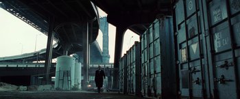Movie still from “Lord of War” (2005), directed by Andrew Niccol – A man in a suit walking down a street; Extreme Wide shot, Low angle