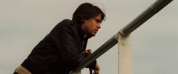 Movie still from “Lord of War” (2005), directed by Andrew Niccol – A man leaning up against a railing; Close Up shot, Low angle
