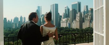 Movie still from “Lord of War” (2005), directed by Andrew Niccol – A man and a woman standing in front of a city skyline; Medium shot, Over the shoulder angle