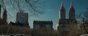Movie still from “Lord of War” (2005), directed by Andrew Niccol – A view of a building from across the street from a park; Extreme Wide shot, Low angle