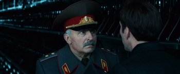 Movie still from “Lord of War” (2005), directed by Andrew Niccol – An older man in a military uniform is talking to another man; Close Up shot, Over the shoulder angle