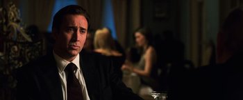 Movie still from “Lord of War” (2005), directed by Andrew Niccol – A person wearing a suit and tie; Close Up shot, Over the shoulder angle