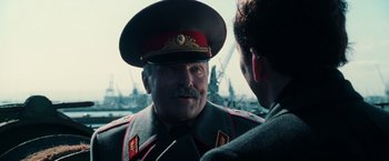 Movie still from “Lord of War” (2005), directed by Andrew Niccol – An older man in a military uniform talking to another man; Close Up shot, Over the shoulder angle