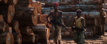 Movie still from “Lord of War” (2005), directed by Andrew Niccol – A man with a red turban on holding a rifle; Medium shot, Low angle