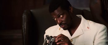 Movie still from “Lord of War” (2005), directed by Andrew Niccol – A man looking at something in his hands; Close Up shot, Low angle