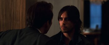 Movie still from “Lord of War” (2005), directed by Andrew Niccol – A man looking at himself in the mirror while talking to another man; Close Up shot, Over the shoulder angle