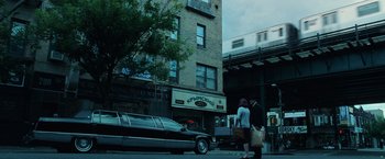 Movie still from “Lord of War” (2005), directed by Andrew Niccol – Two people walking down the street in front of a limo; Extreme Wide shot, Low angle