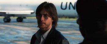 Movie still from “Lord of War” (2005), directed by Andrew Niccol – A man with long brown hair wearing a leather jacket; Close Up shot, Over the shoulder angle