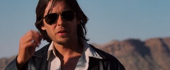 Movie still from “Lord of War” (2005), directed by Andrew Niccol – A person wearing sunglasses and a leather jacket; Close Up shot, Low angle