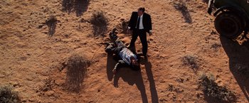 Movie still from “Lord of War” (2005), directed by Andrew Niccol – A man in a suit and tie standing next to another man in a suit and tie; Wide shot, Overhead angle