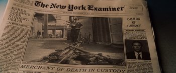 Movie still from “Lord of War” (2005), directed by Andrew Niccol – An old new york newspaper with a picture of a man standing next to guns; Extreme Close Up shot, High angle