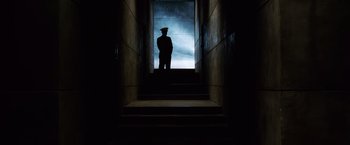 Movie still from “Lord of War” (2005), directed by Andrew Niccol – A man standing on the stairs of a building; Wide shot, Low angle