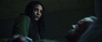 Movie still from “Lost Bullet 2: Back for More” (2022), directed by Guillaume Pierret – A woman with dreads is looking at the camera; Close Up shot, Low angle