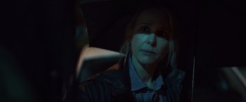 Movie still from “Lost Bullet 2: Back for More” (2022), directed by Guillaume Pierret – A woman is holding an umbrella in the dark; Close Up shot, Over the shoulder angle