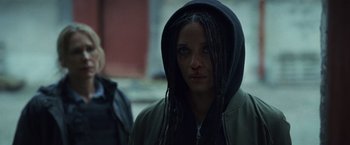 A woman with dreadlocks wearing a hooded jacket