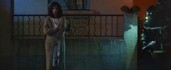 Movie still from “Lost Bullet 2: Back for More” (2022), directed by Guillaume Pierret – A woman standing in front of a railing at night; Wide shot, High angle