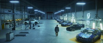 Movie still from “Lost Bullet 2: Back for More” (2022), directed by Guillaume Pierret – A man is walking in an empty warehouse; Extreme Wide shot, High angle