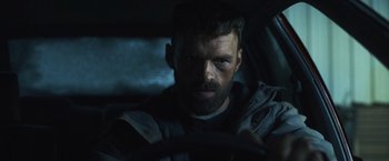 Movie still from “Lost Bullet 2: Back for More” (2022), directed by Guillaume Pierret – A person in a car; Close Up shot, Low angle