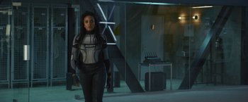Movie still from “Lost Bullet 2: Back for More” (2022), directed by Guillaume Pierret – A woman standing in a room; Medium shot, Low angle