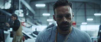 Movie still from “Lost Bullet 2: Back for More” (2022), directed by Guillaume Pierret – A man with a beard is looking at the camera; Close Up shot, Low angle